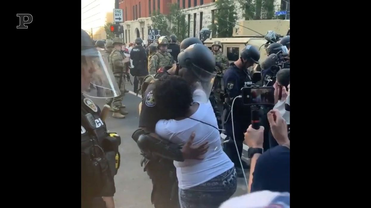 Scontri Usa, l'abbraccio tra l'agente e la manifestante
