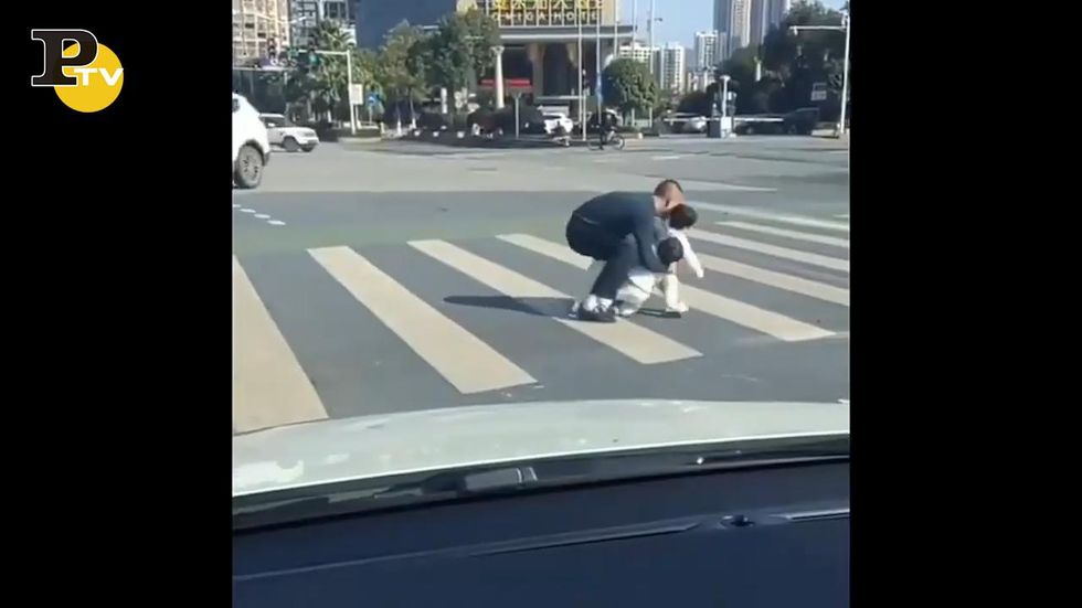 Il papà raccoglie i bambini che attraversano la strada