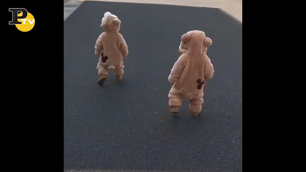 Bambini vestiti da orsacchiotti camminano per strada