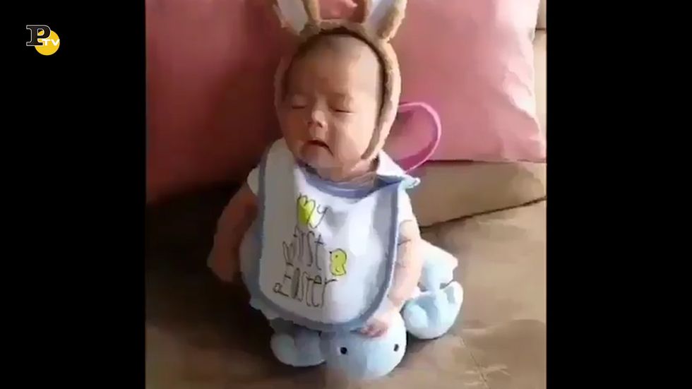 Un bambino mezzo addormentato fa uno starnuto e cade