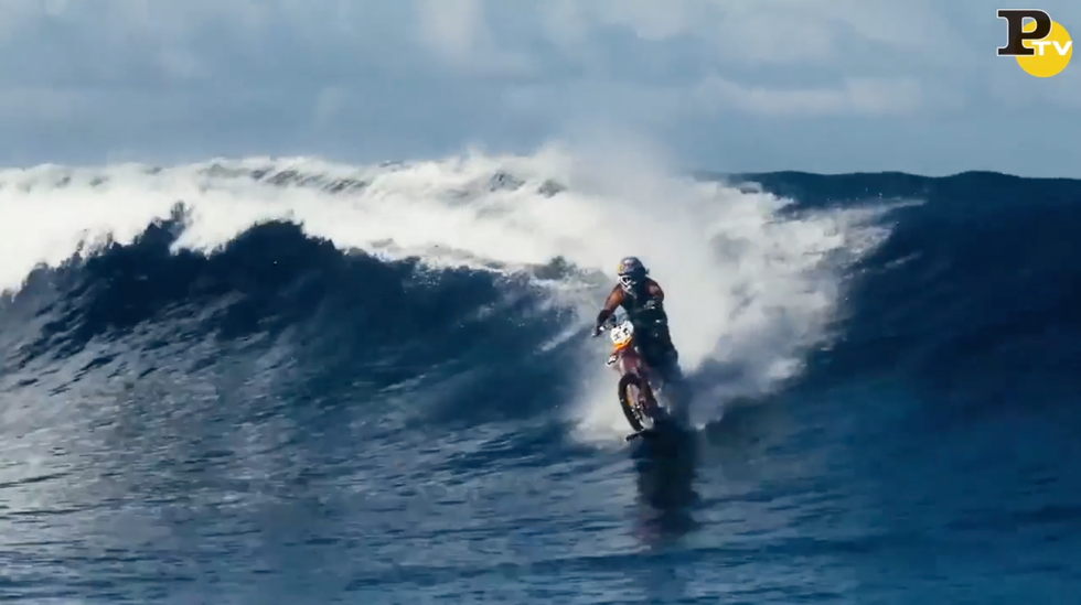 Il biker fa surf sulle onde con la moto da cross