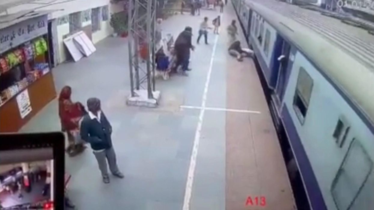 India, uomo scivola sotto un treno: salvato da un soldato | video