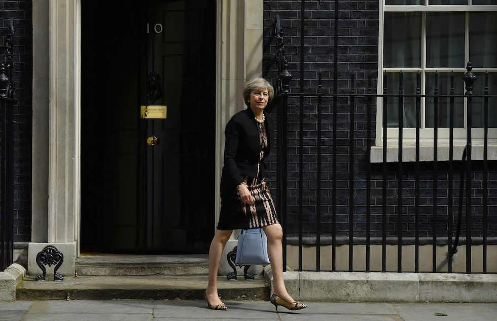 Stiletto animalier sulla gamba nuda per Theresa May in uscita dal 10 di Downing Street