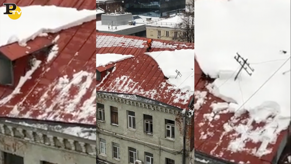 uomo cade tetto spala neve Mosca video