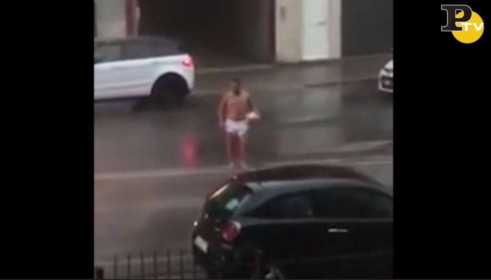 Uomo gira nudo per strada con un pallone sotto braccio video