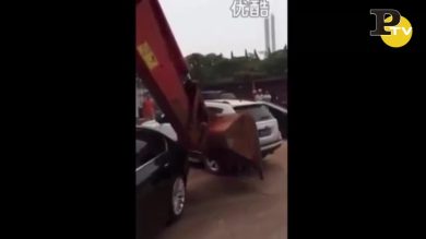 Escavatore sposta le auto che lo intralciano