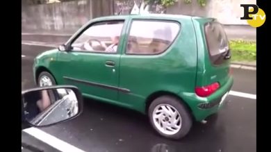 Al volante dell’auto una donna guida con il freno a mano tirato