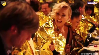 Charlize Theron con la coperta termica dei migranti a cena di gala
