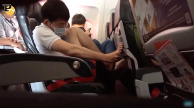 Ragazzo si pulisce i piedi in aereo | video