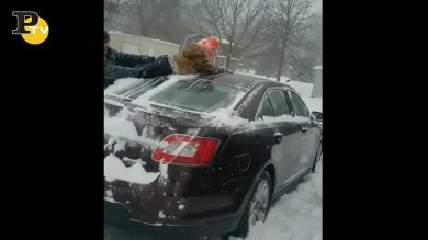 Papà usa il figlio per pulire la macchina dalla neve