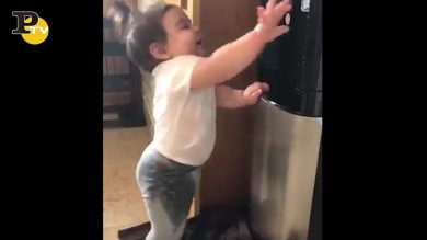 Bambina scopre come usare il distributore dell’acqua