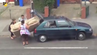 Famiglia cerca di mettere un divano del baule della macchina