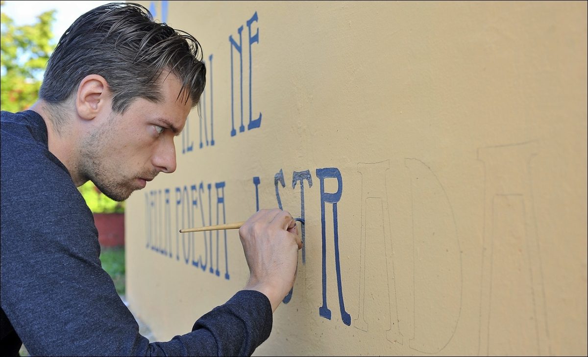 Il graffitaro che porta la poesia sulle saracinesche